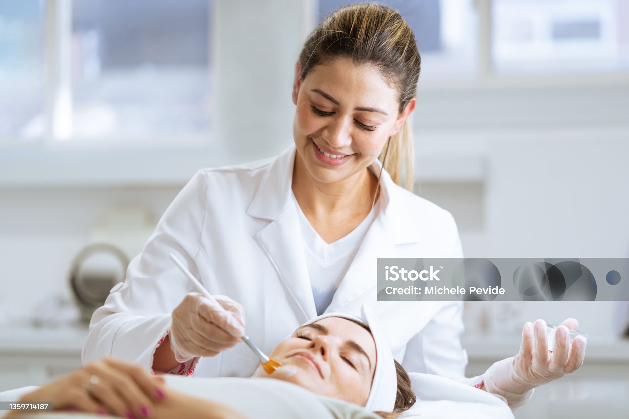 Female dermatologist performing a procedure on a client